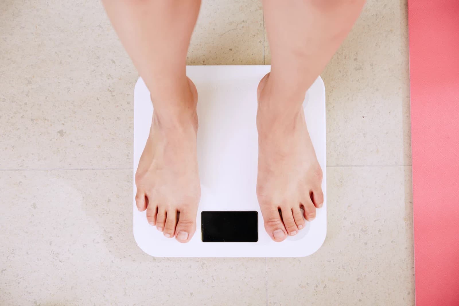 A person standing on a bathroom weighing scale.